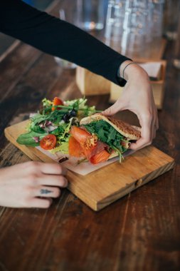 salata tavuk ve tofu sandviçle tutan eller