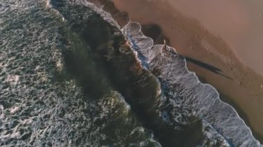 Sörfçü okyanus deniz kıyısında yanında yürüyor