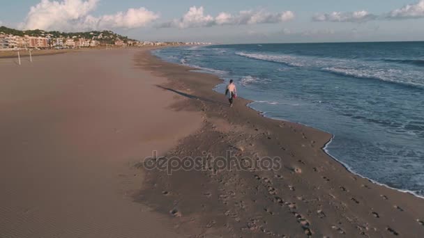 Sörfçü okyanus deniz kıyısında yanında yürüyor — Stok video