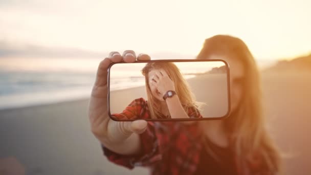 Девушка снимает селфи на телефон — стоковое видео