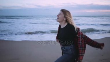Sahilde günbatımı veya alacakaranlık zaman mutlu sarışın kız
