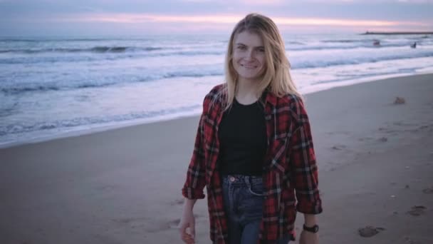 Menina loira feliz na praia ao pôr do sol ou crepúsculo — Vídeo de Stock