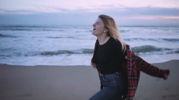 Menina loira feliz na praia ao pôr do sol ou crepúsculo — Vídeo de Stock