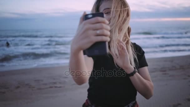 Felice ragazza bionda sulla spiaggia al tramonto o al crepuscolo — Video Stock