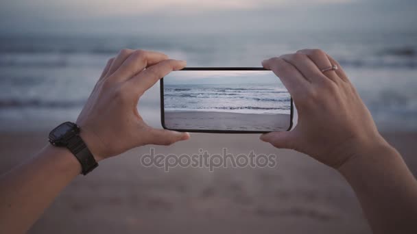 Filmar ondas na praia no crepúsculo em novo smartphone com tela larga — Vídeo de Stock