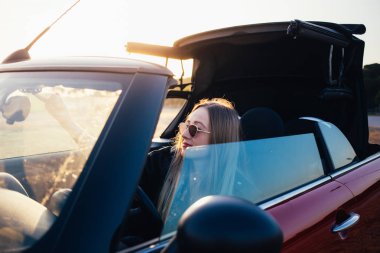 gün batımında arabada oturan genç kadın portresi