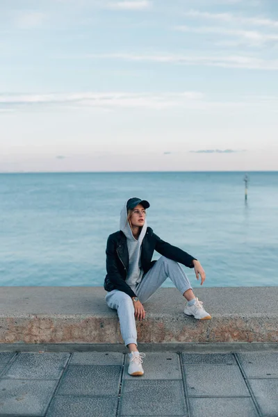 Retrato Mujer Joven Con Capucha Gris Pantalones Chándal Sentados Muelle — Foto de Stock