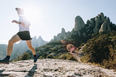 Güçlü ve sağlıklı atletik erkek, yapar egzersiz açık havada dağ yolu üzerinde ultra trail maraton sırasında. Güneşli fişekleri şaşırtıcı doğa manzara manzara üzerinde belirlenen kazanmak ve spor başarılı