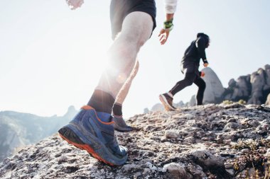 İki arkadaş ya da sporcular kayalık dağ arazi yol veya iz yüksek dağlarda veya sahil, sağlıklı yaşam tarzı seçimi ve zor egzersiz planı üzerinde çalıştırın. Güneş hareket ilham verici lense flare