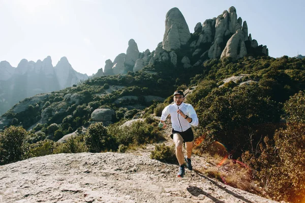 Fast and strong, fit athletic man runs on mountain path or trail during ultra marathon race, hard training workout, healthy lifestyle choice to spend time outdoors in nature in national park