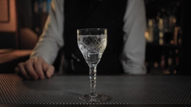 Barkeeper fügt Oliven zu sauberem trockenen Martini-Cocktail hinzu — Stockvideo