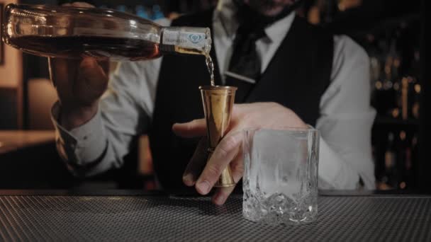 专业和熟练的工匠酒保在酒吧倾吐酒或酒精饮料入跳汰机 然后在威士忌或 Scoth 玻璃在昂贵和邀请仅创立 — 图库视频影像