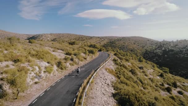 Hipster uomo cavalca su skateboard su strada di montagna — Video Stock