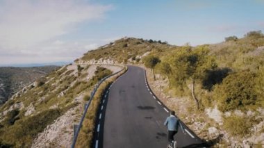 Dağ yolu üzerinde kaykay üzerinde hipster adam rides