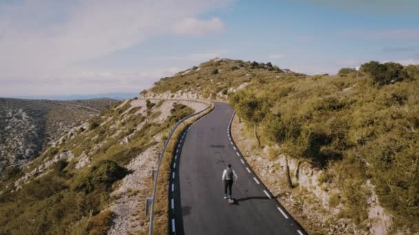 Dağ yolu üzerinde kaykay üzerinde hipster adam rides — Stok video