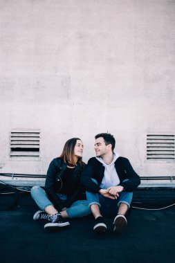 Sevimli ve güzel genç millennials çatı veya endüstriyel mahallede birkaç birbirlerine bakıyorlar, gülmek ve geçiş duygu ve gerçek duygularını, dikey hikayeler uygun alanı metin ile gülümse