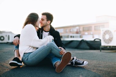 Harika serin ve çekici çift romantik Tarih üzerinde oturmak çatı güzel günbatımı ışık sızıntıları, sarılmak ve sarılmak, bak birbirlerine romantik şekilde gençler aşık, millennials yaşam tarzı çılgın