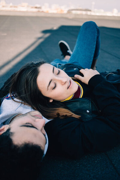 Привлекательная и стильная, естественная красота и эмоции пара лежит на полу на крыше или террасе в солнечный день, расслабиться и расслабиться, позировать для профессиональной фотосессии, как модели, реальные чувства романтики
