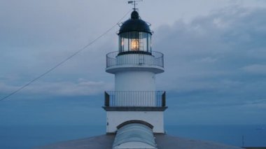 Eski deniz feneri alacakaranlıkta moody gökyüzü arka plan üzerinde çalışıyor