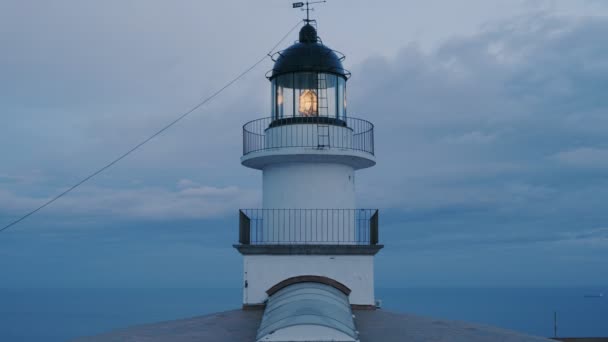 古い灯台は不機嫌そうな空を背景に夕暮れで働いてください。 — ストック動画