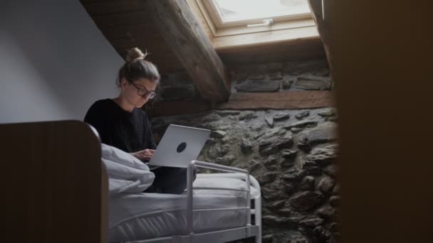 Frilansare arbetar i hostel på sin laptop — Stockvideo