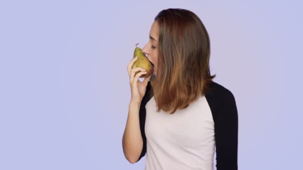 Beautiful woman holds fresh tasty pear — Stock Video