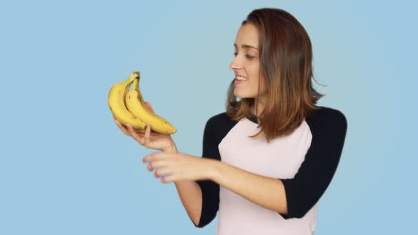 Vrij lachende vrouw houdt bos van bananen — Stockvideo