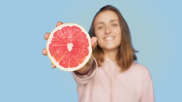 Linda mujer sonriente feliz sostiene pomelo rosa — Vídeo de stock