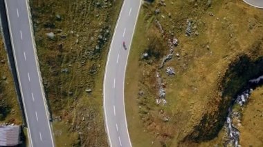 Yol bisikletçisi gün batımında dağ dönüşlerine tırmanıyor.