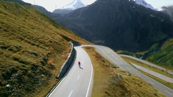 Ciclista de carretera sube por la puesta de sol montaña switchbacks — Vídeos de Stock