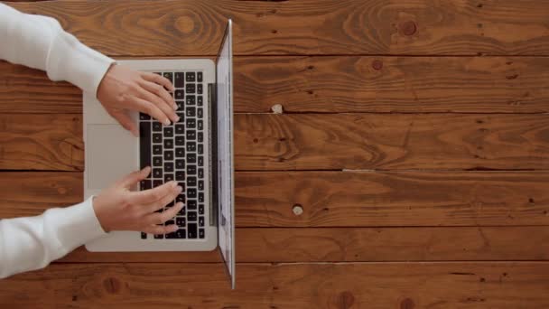 Руки женщины печатают поверх клавиатуры ноутбука — стоковое видео