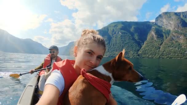 Gelukkig meisje reiziger op kajak met schattig hond — Stockvideo