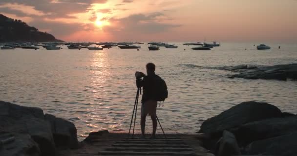 Fotograf tworzy zawartość z aparatem fotograficznym w zachodzie słońca — Wideo stockowe