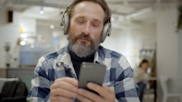 Portrait of handsome senior man in headphones — Stock Video