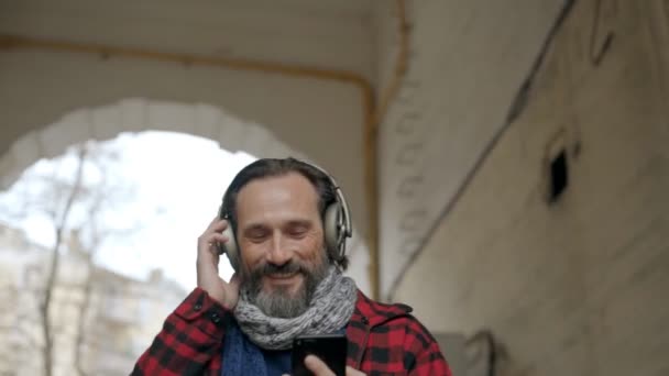 Portrét pohledného staršího muže ve sluchátkách — Stock video