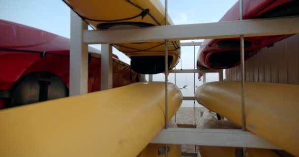 Canoas y kayaks apilados en estantes de alquiler — Vídeo de stock