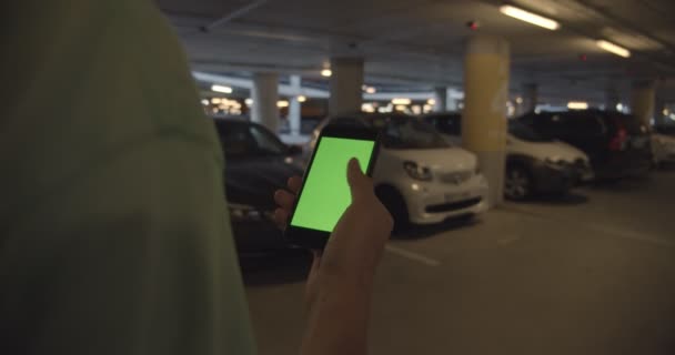 Homem procura carro compartilhado estacionado no aplicativo de telefone — Vídeo de Stock