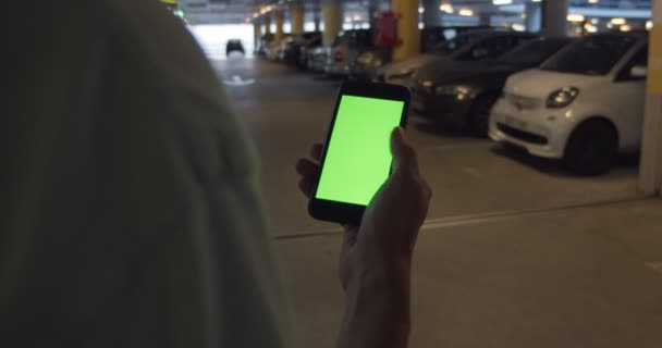 Hombre busca coche compartido estacionado en la aplicación de teléfono — Vídeos de Stock