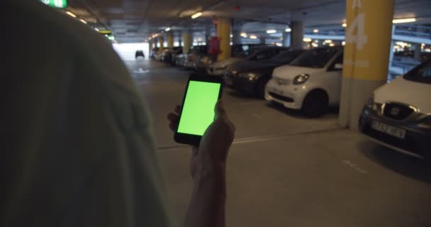 Людина шукає припарковану машину на телефонній програмі — стокове відео