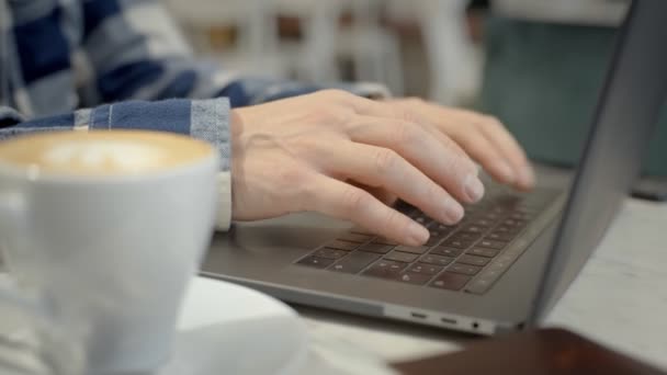 Manliga händer typ på laptop tangentbord i café — Stockvideo