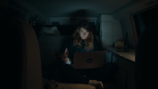 Woman with laptop inside camping van at night — Stock Video