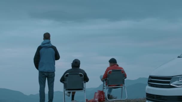 Vrienden hangen rond camper bij zonsondergang — Stockvideo
