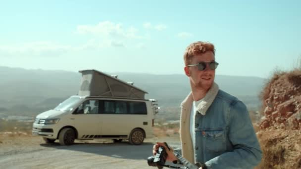 Young hipster man makes photos of camper van — Stock Video