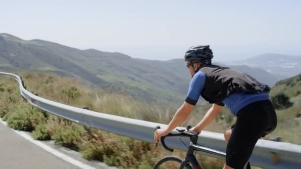 Professionell vägcyklist på cykel i fjällen — Stockvideo