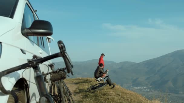 Amigos activos al aire libre ven la puesta de sol desde la cima de la colina — Vídeo de stock