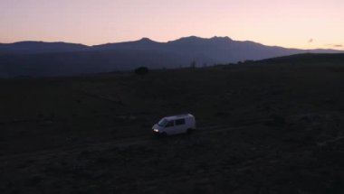 Gün batımında güneş paneli olan off-road kamp aracı.