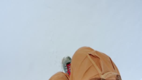 Homme en pantalon orange et bottes bleues marchent sur la neige — Video