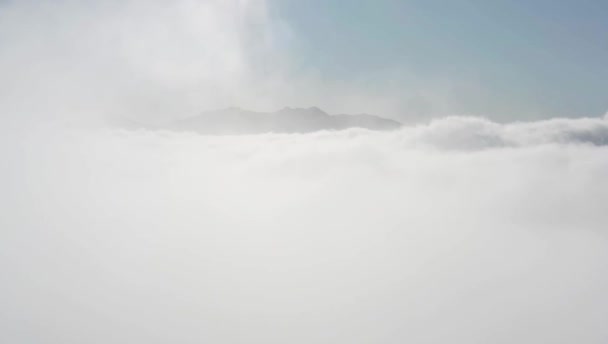 Aerial drone shot over clouds in mountains — Stock Video