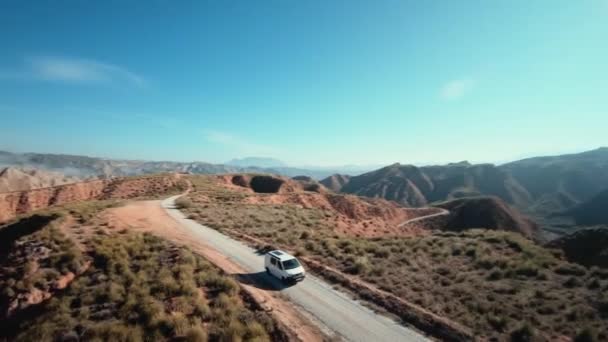 Luchtopname van kampeerbusje op onverharde bergweg — Stockvideo