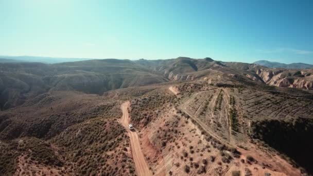 Аэросъемка кемпингового фургона на грунтовой горной дороге — стоковое видео